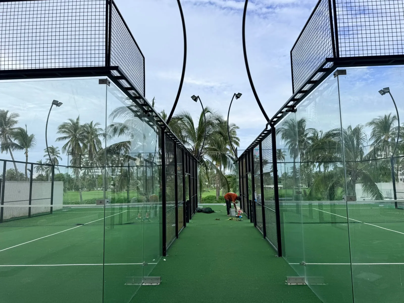 Dos canchas de pádel contiguas con cinturón perimetral de acero y luminarias en postes curvos en Acapulco