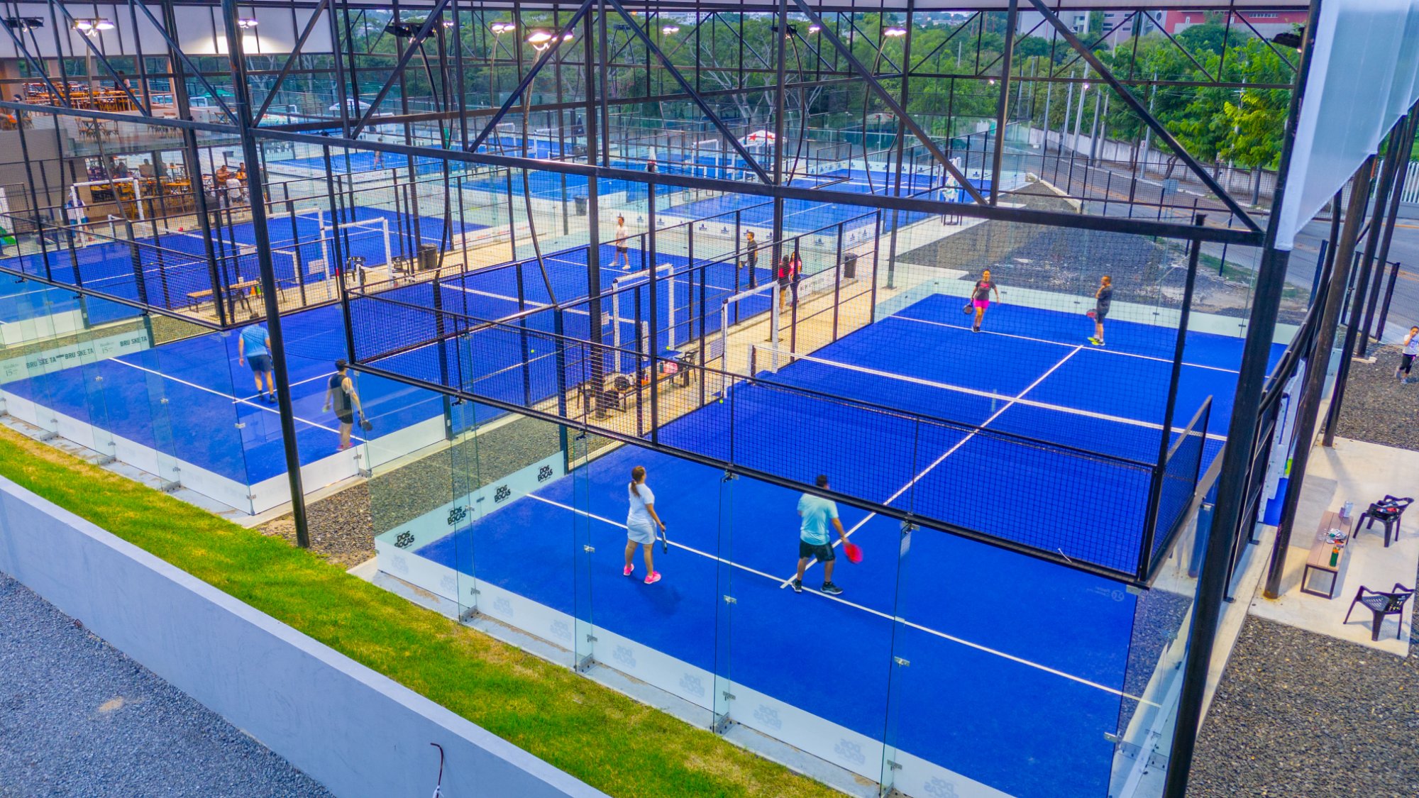 Club de pádel nocturno con canchas en perfectas condiciones tras mantenimiento integral — pasto verde, cristales limpios e iluminación uniforme