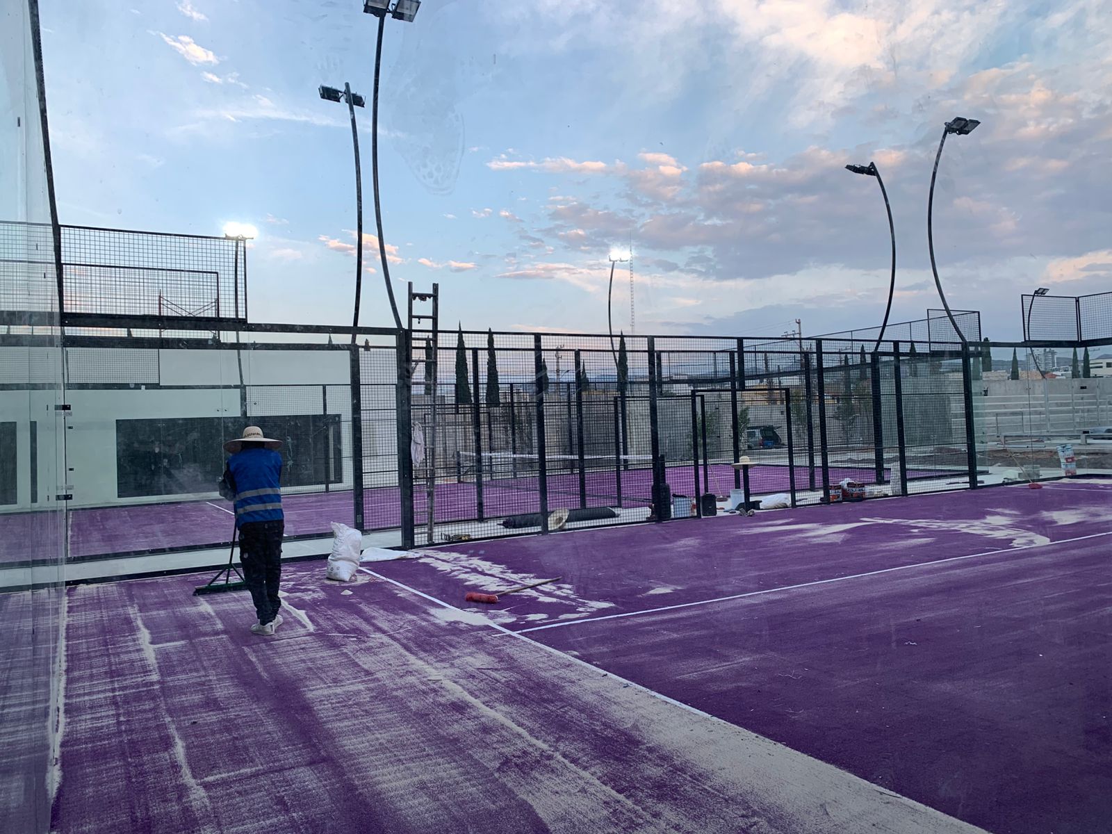 Cancha morada de pádel en proceso de instalación al atardecer