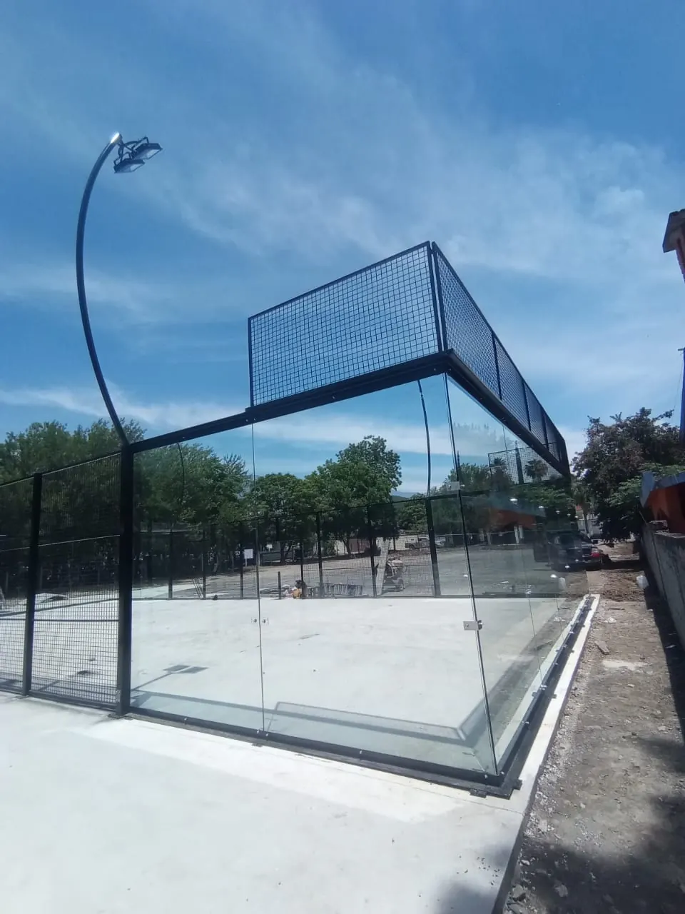 Esquina de cristal templado en cancha de pádel durante montaje