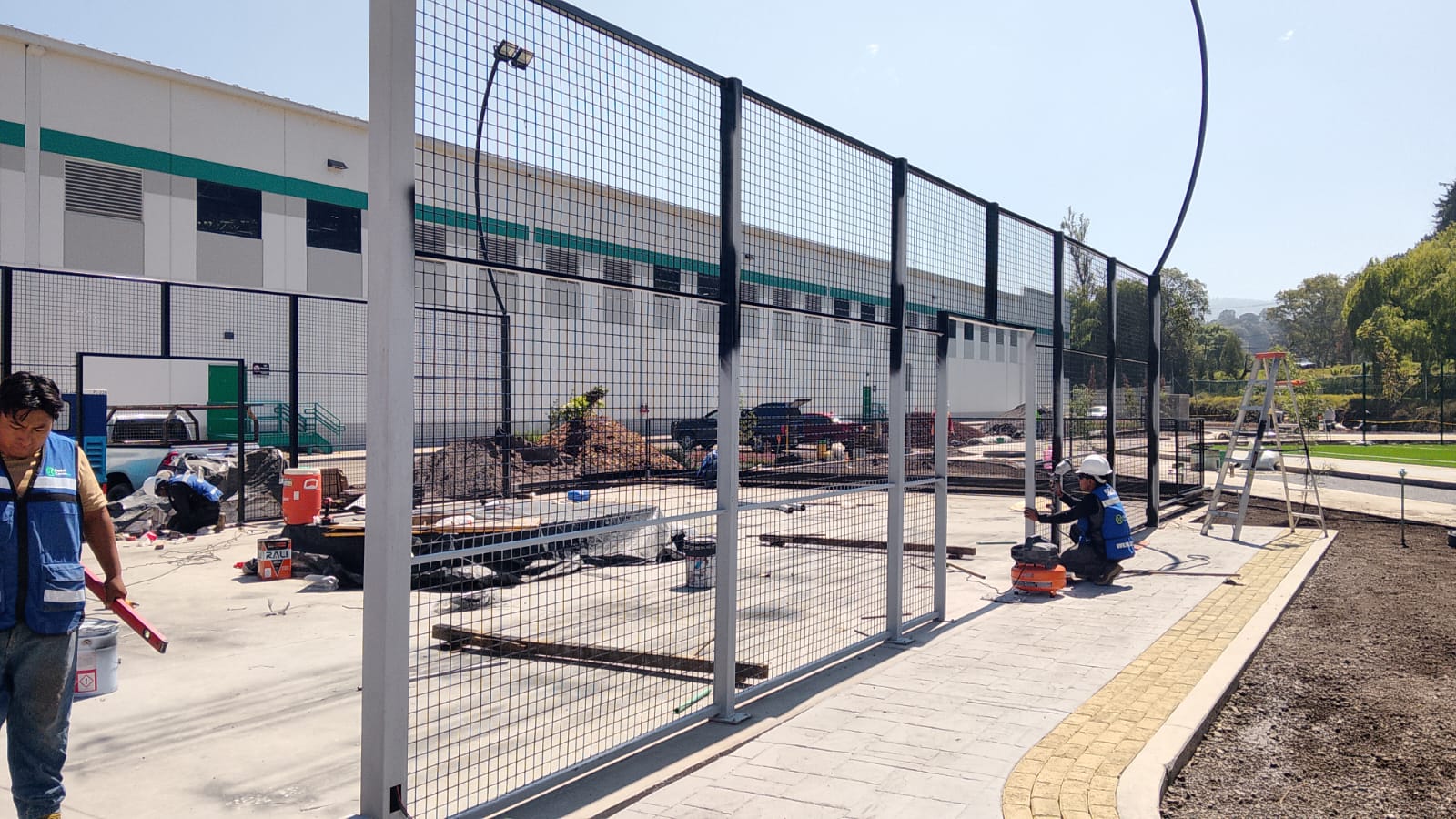 Instalación de malla y estructura blanca en cancha de pádel